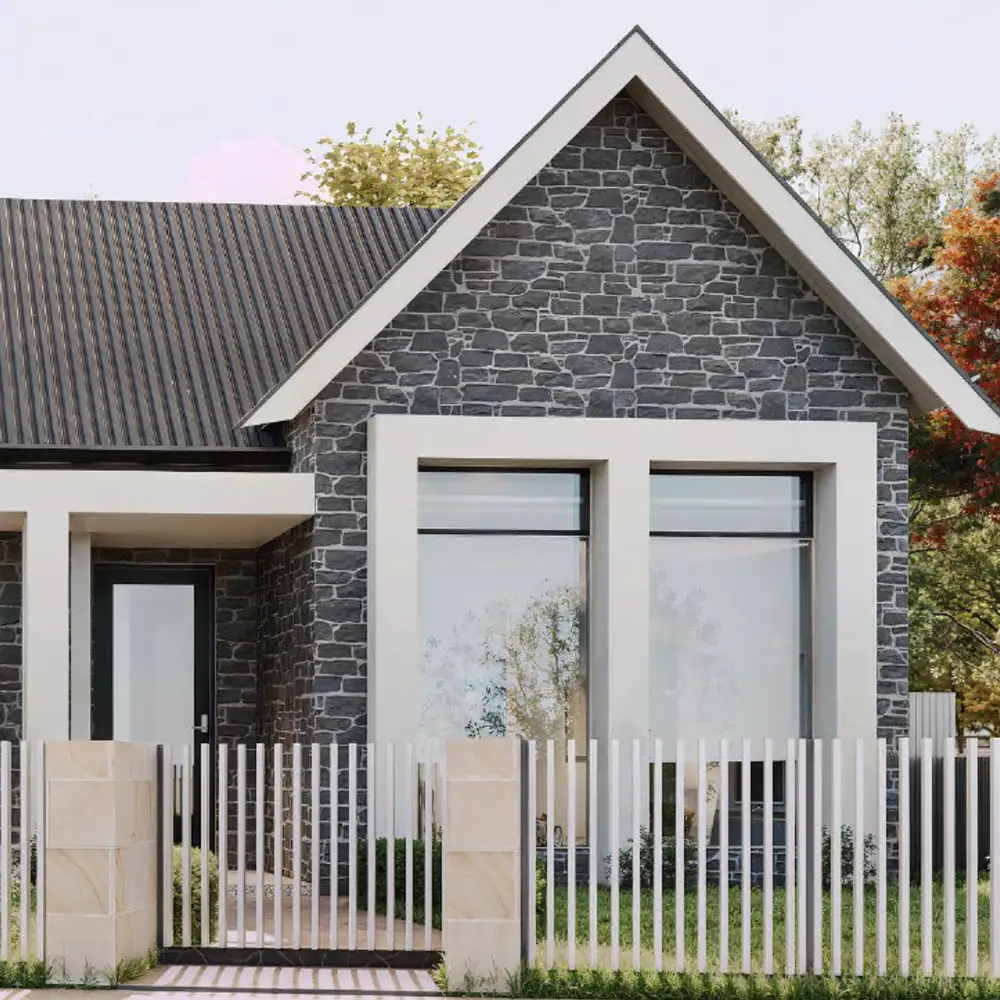 Modern stone-clad home with dark roof, large windows, and white picket fence.