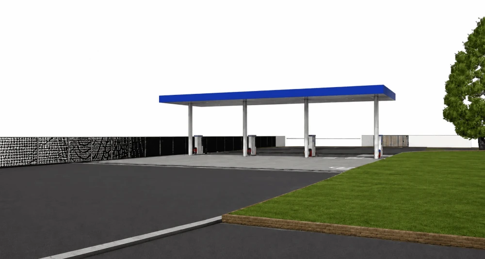 Modern gas station canopy with fuel pumps, paved forecourt, and landscaped surroundings.